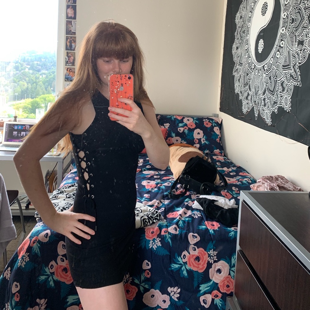 Black form fitting dress, laced up on the sides
